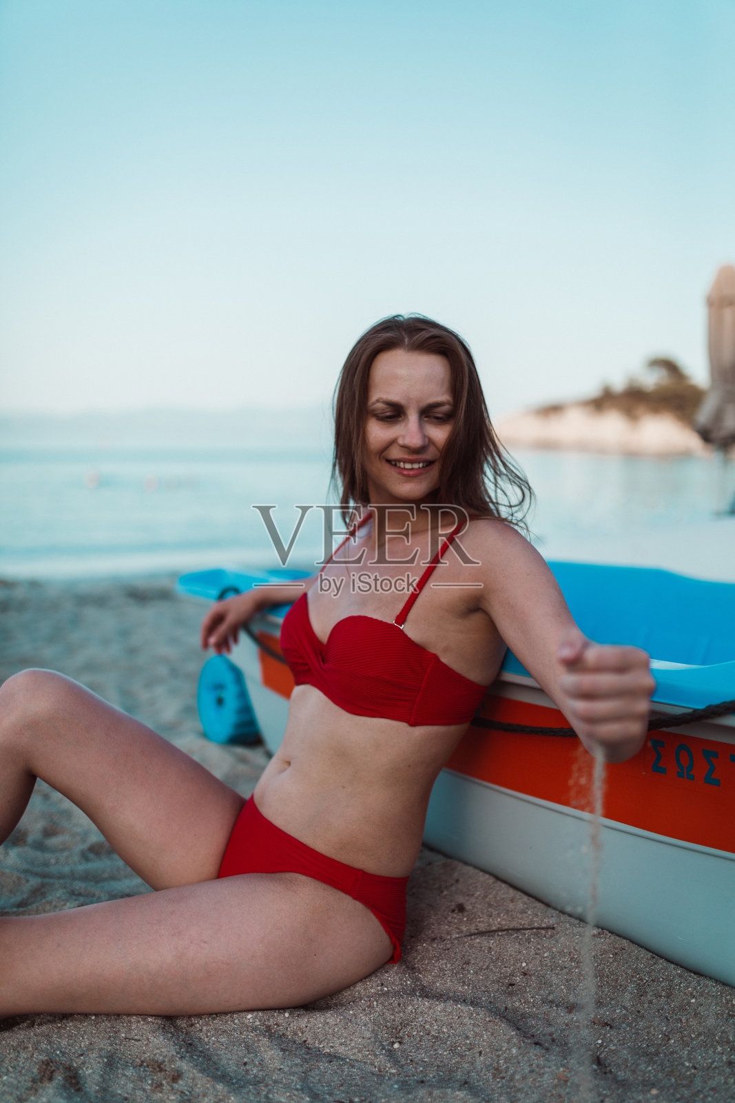 一个在阳光明媚的日子里在海滩上放松的漂亮女人照片摄影图片