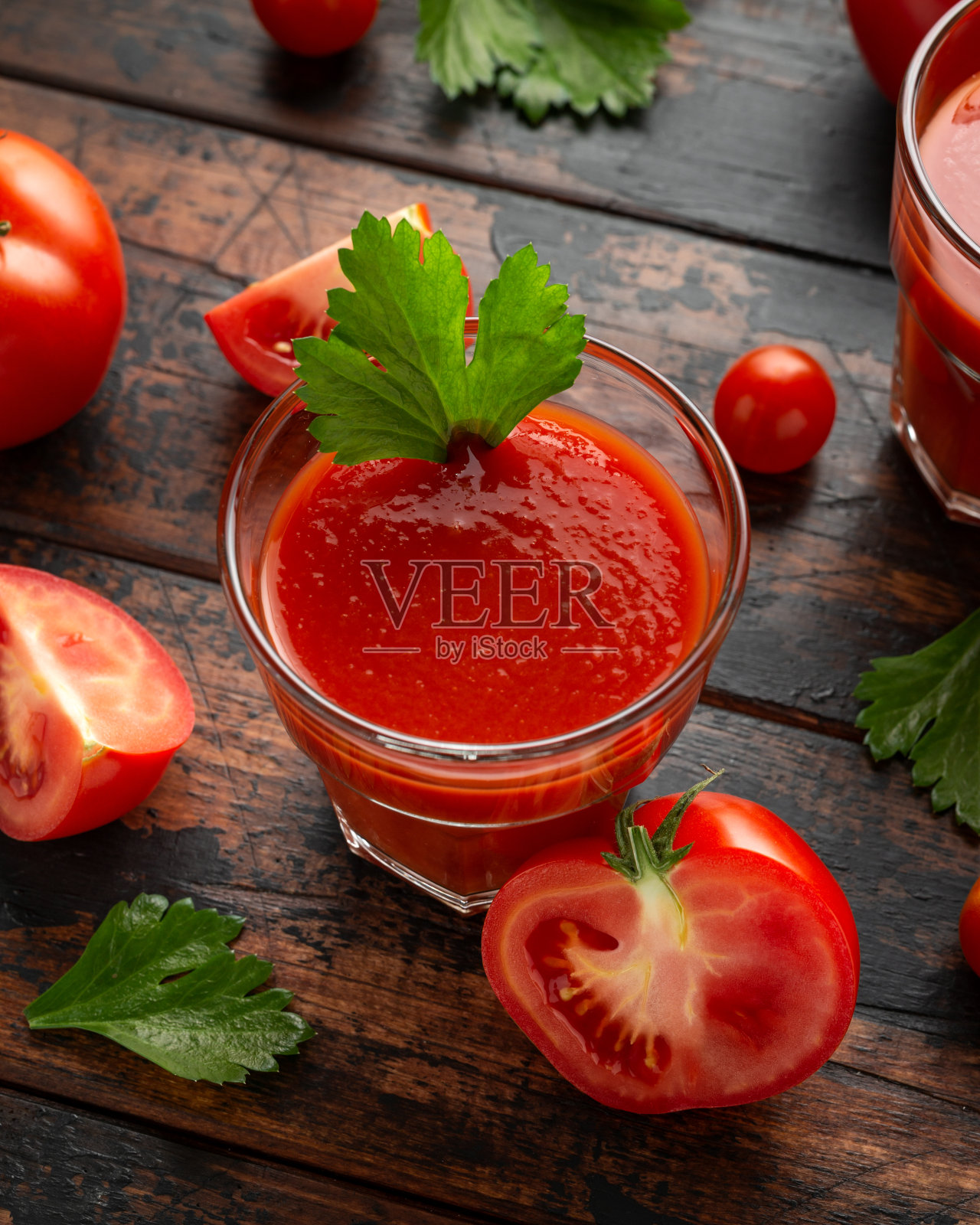 玻璃杯里的番茄汁和芹菜放在质朴的木桌上照片摄影图片