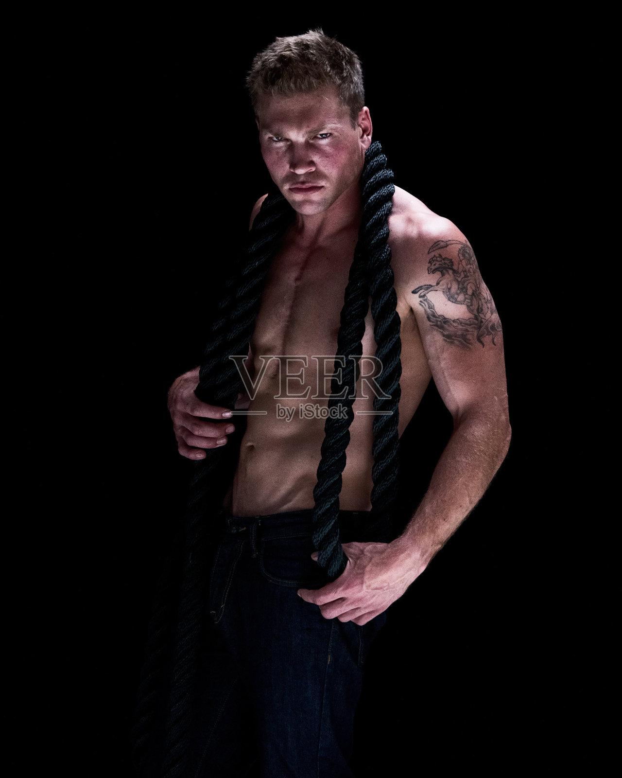 性感的男人拿着黑色的绳子照片摄影图片