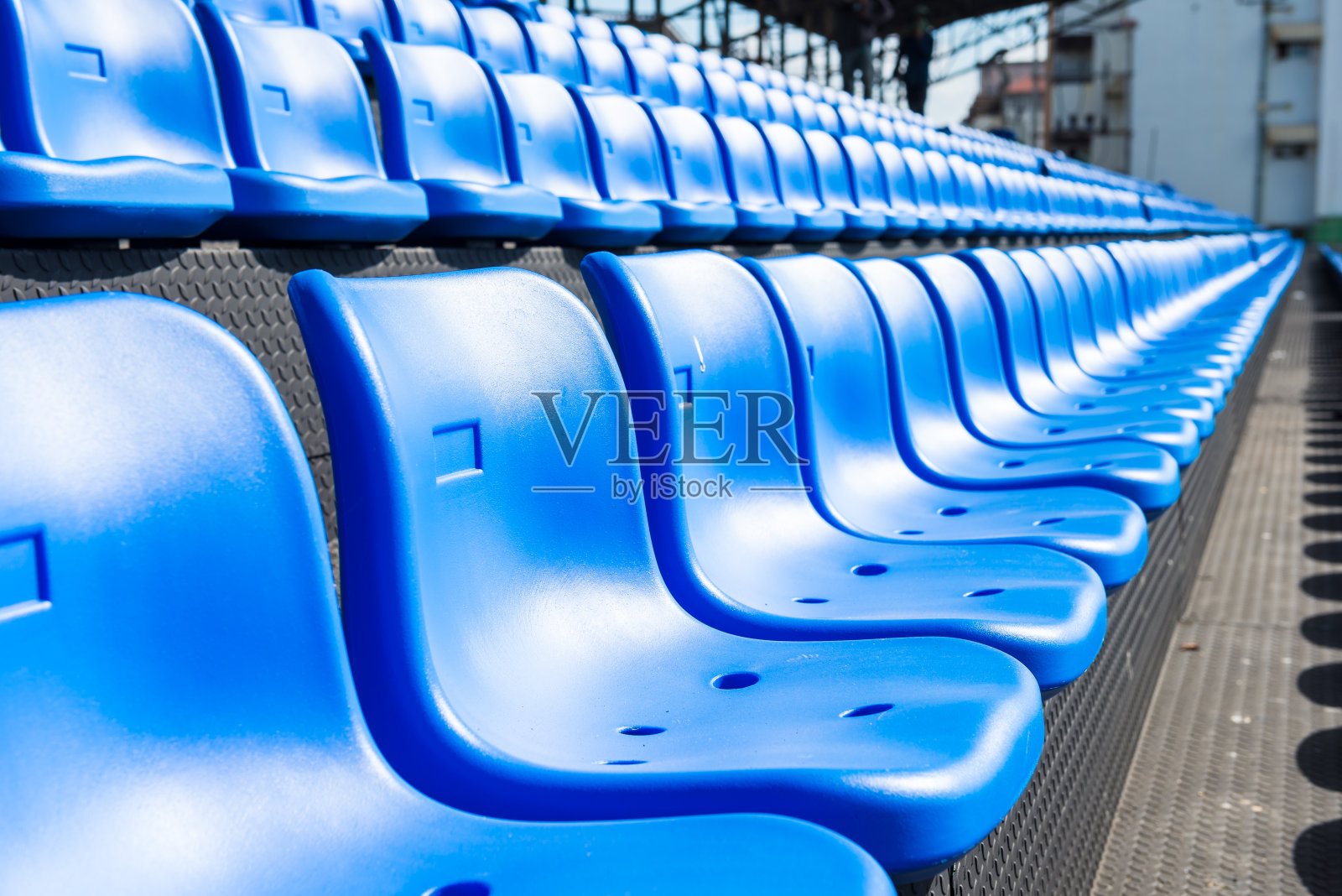 足球场正面看台的蓝色座位。照片摄影图片