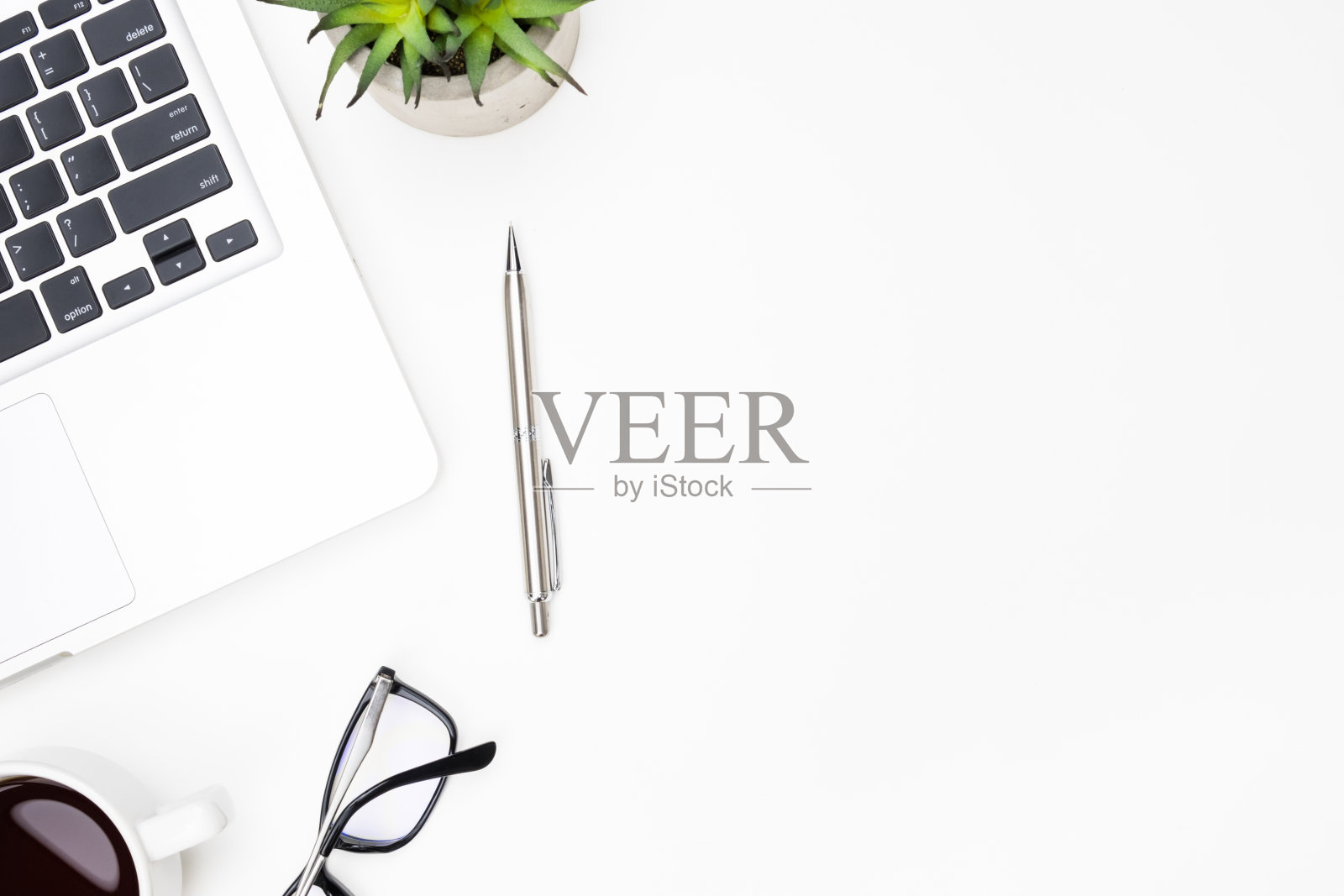 白色的办公桌旁有笔记本电脑，一杯咖啡和其他用品。顶视图与复制空间，平放。照片摄影图片