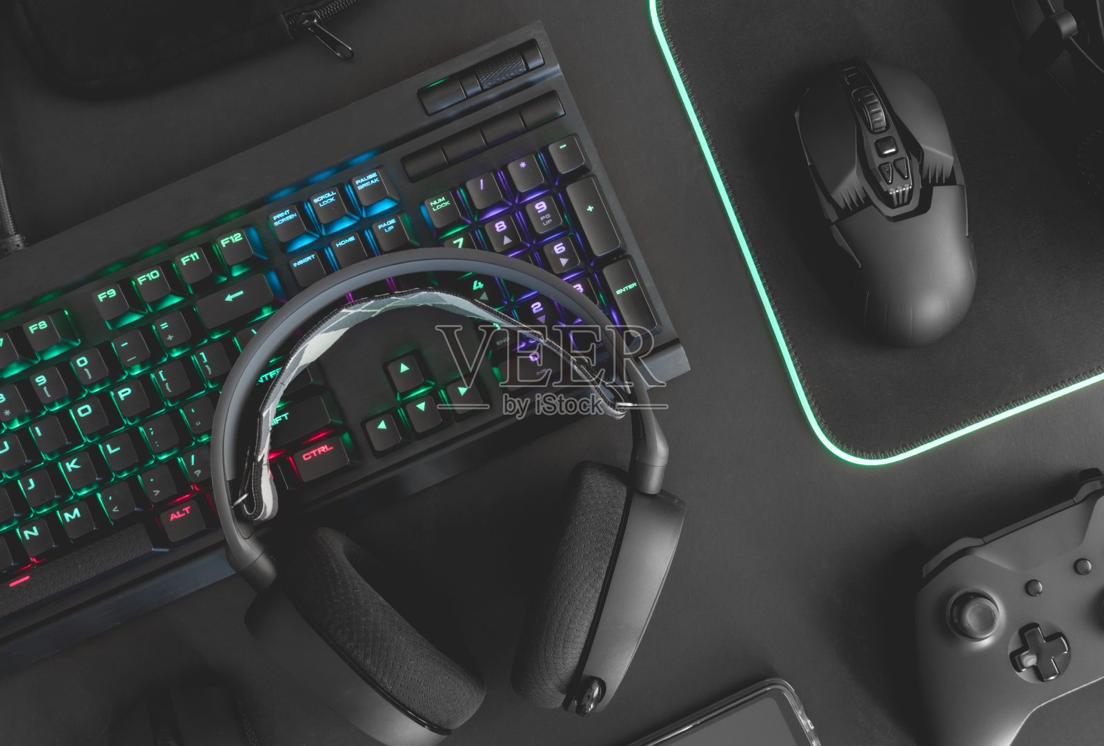 电子竞技概念，俯视图一个游戏设备，鼠标，键盘，操纵杆，耳机，移动操纵杆，在耳机和鼠标垫上的黑色桌面背景。照片摄影图片