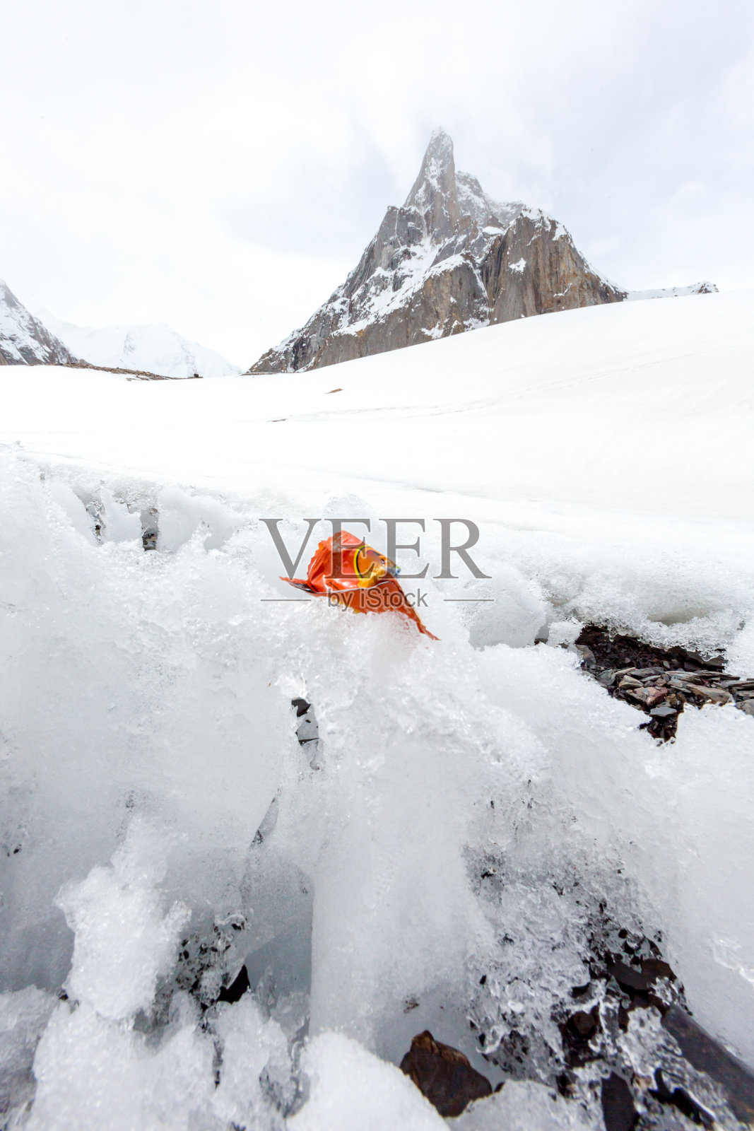 垃圾散落在雪山上。让我们拯救地球，回收多余的垃圾。照片摄影图片