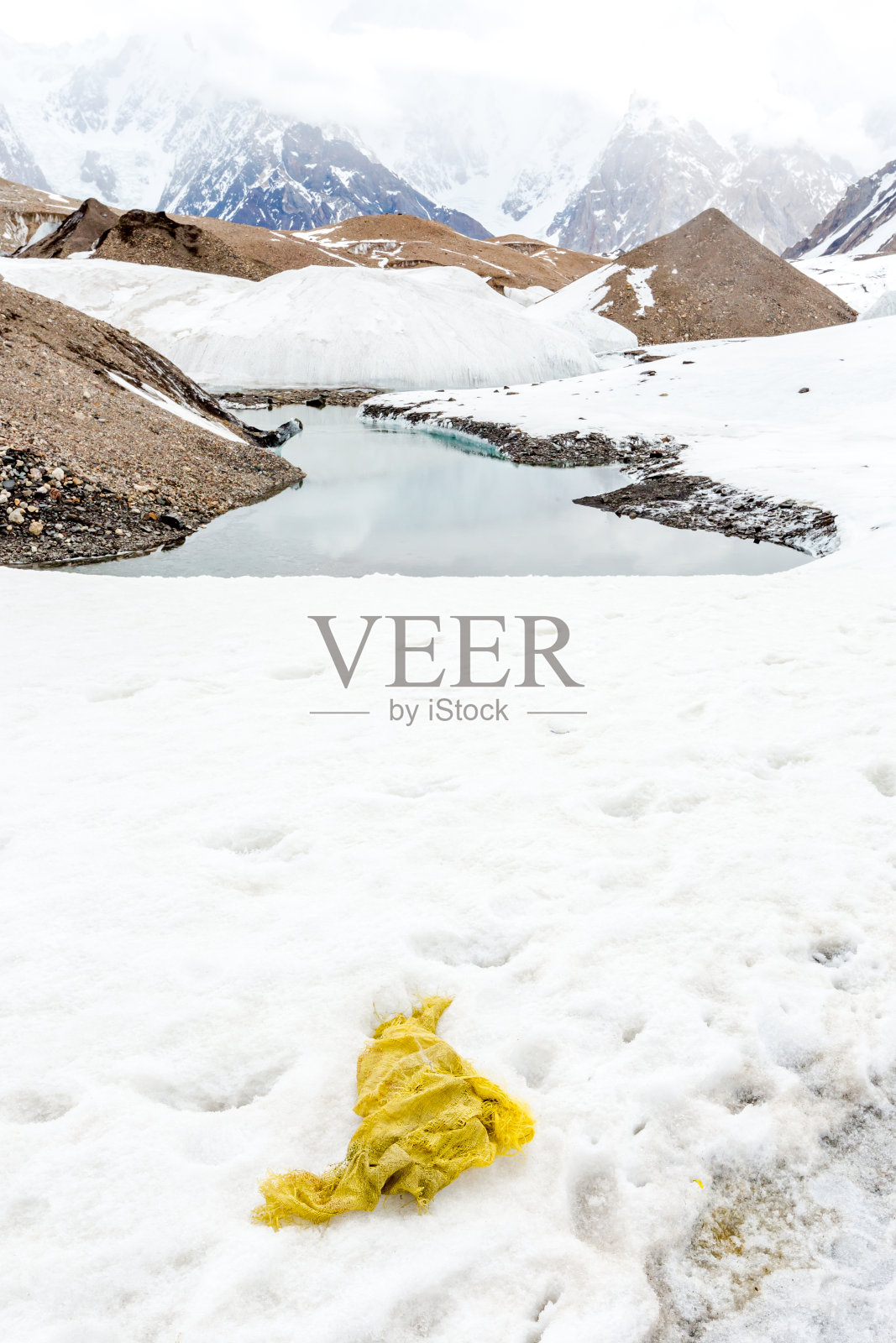 垃圾散落在雪山上。让我们拯救地球，回收多余的垃圾。照片摄影图片