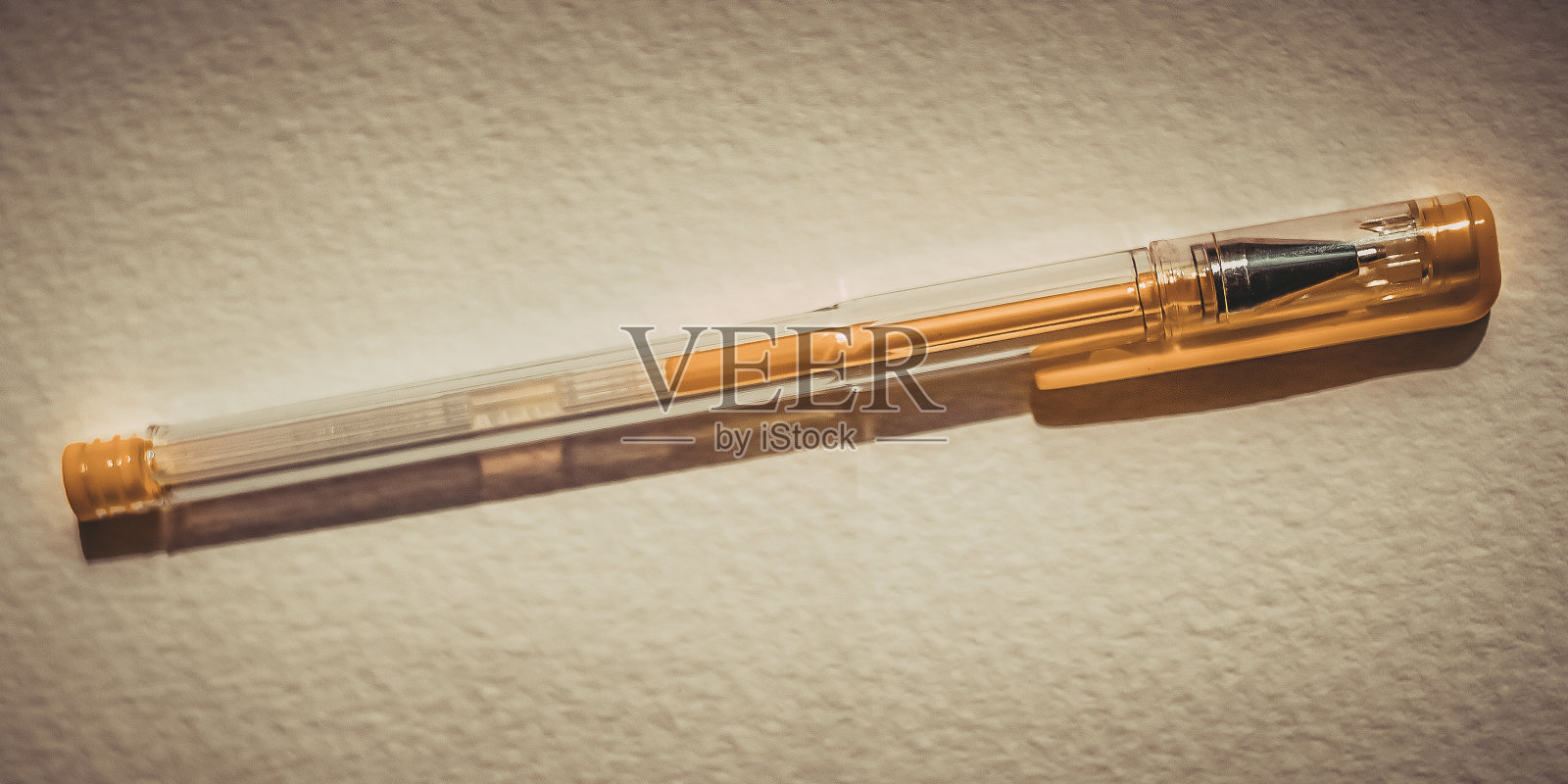 黄色的工笔笔在白色的纹理纸上。照片摄影图片