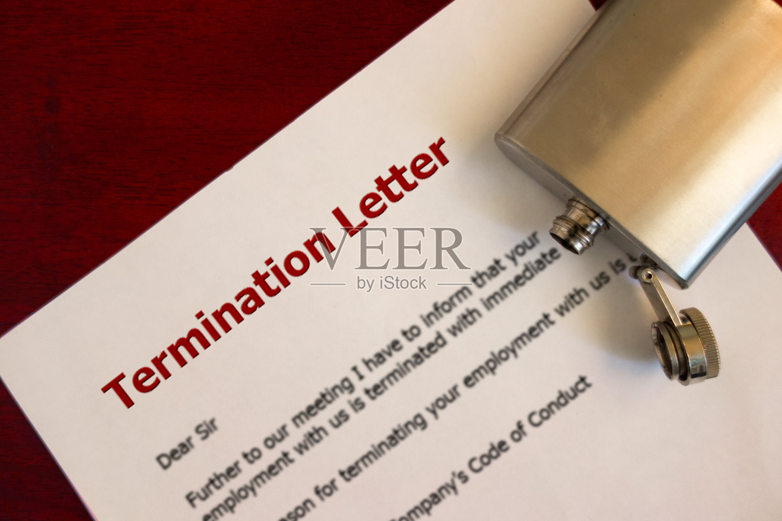 失业问题概念：员工离职通知单和空烧瓶在桌上，酗酒和失业，因被解雇后饮酒导致的心理抑郁照片摄影图片