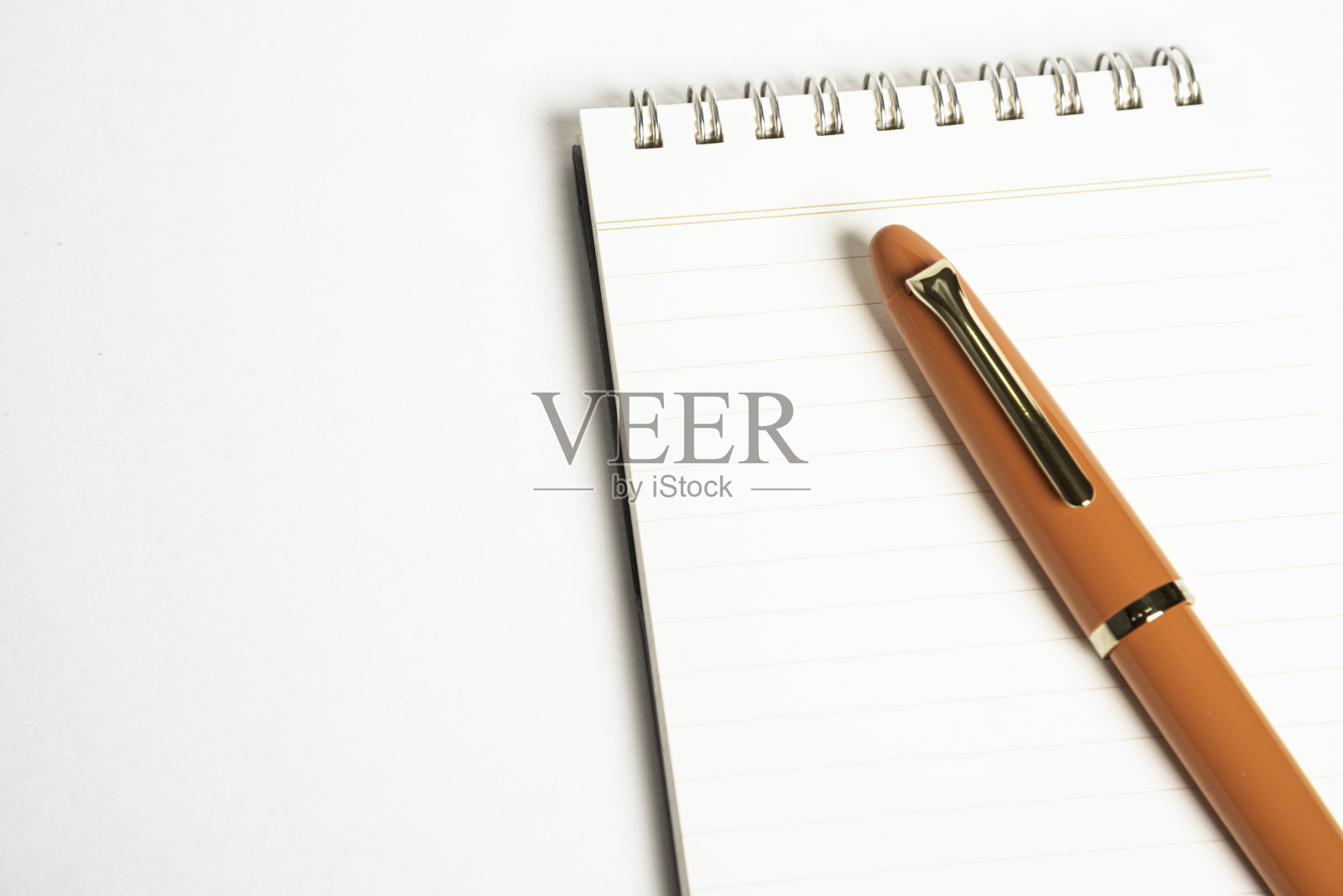 橙色钢笔和螺旋装订笔记本照片摄影图片