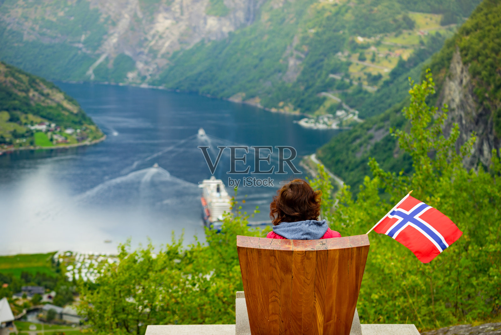 在盖兰格峡湾，游客举着挪威国旗照片摄影图片