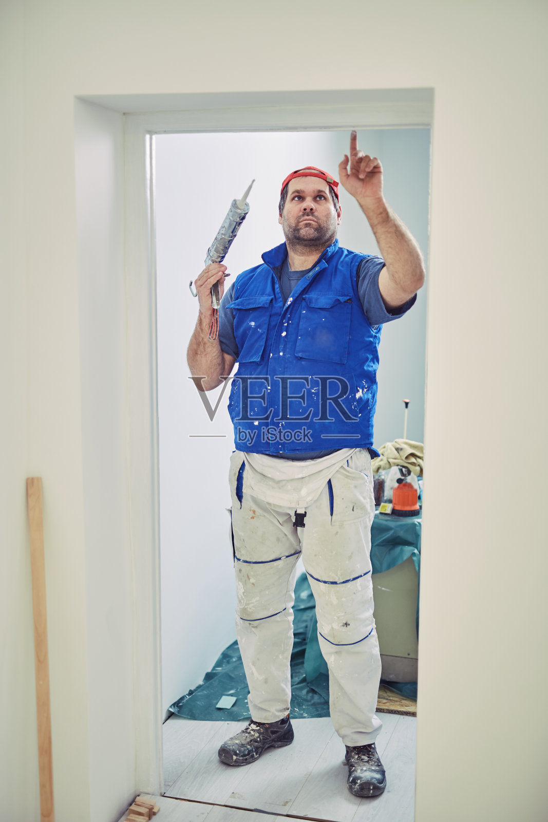 工人用硅树脂做墙和门框在房子里，装修修复。照片摄影图片