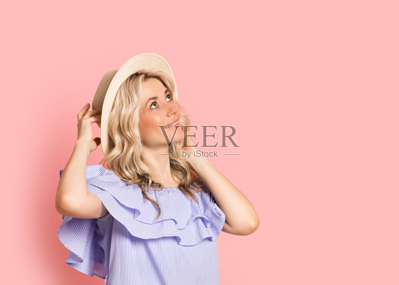 金发女人美丽的微笑肖像在蓝色的裙子，夏天白种人和斯堪的纳维亚女孩在粉红色的背景，度假照片摄影图片