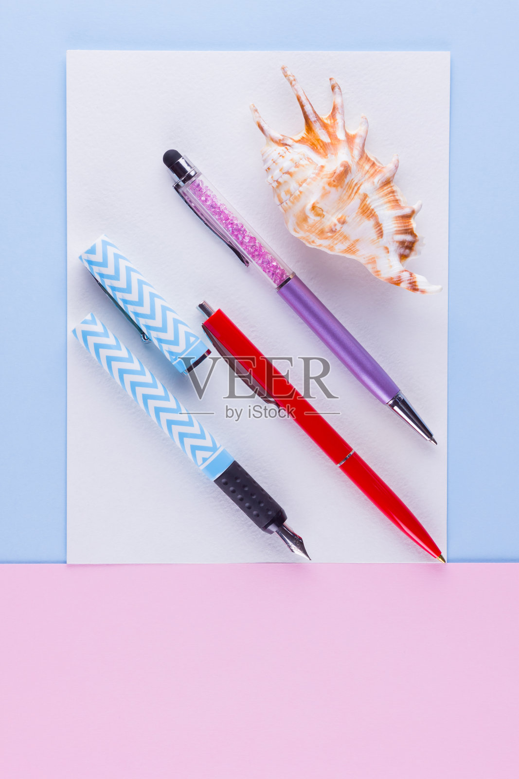 回到学校波普艺术的概念。粉蓝色背景的学校文具和贝壳。彩色粉笔背景上的彩色笔。平的。本空间照片摄影图片