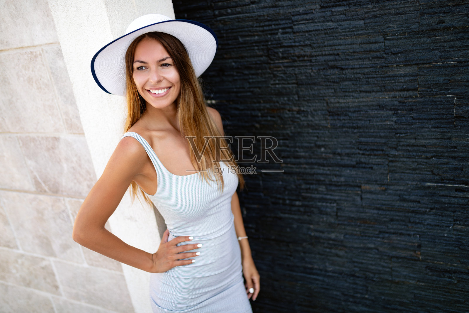 一个戴着帽子的漂亮女人的肖像。笑的女孩。夏天的时间照片摄影图片