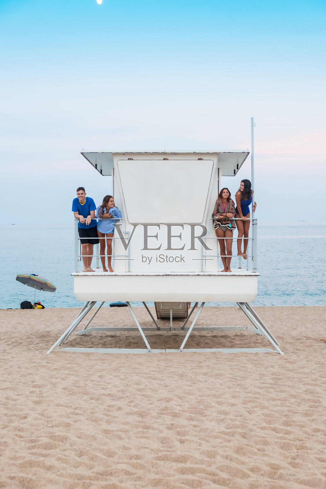 一群朋友在地中海海滩上的救生舱里照片摄影图片