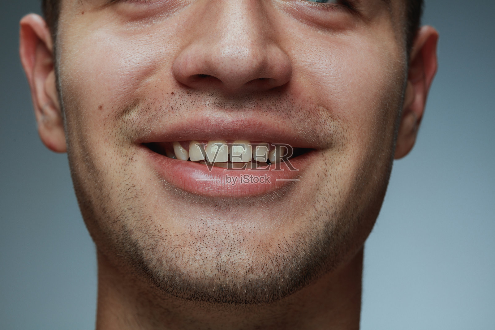 特写的年轻男子孤立在灰色的工作室背景照片摄影图片