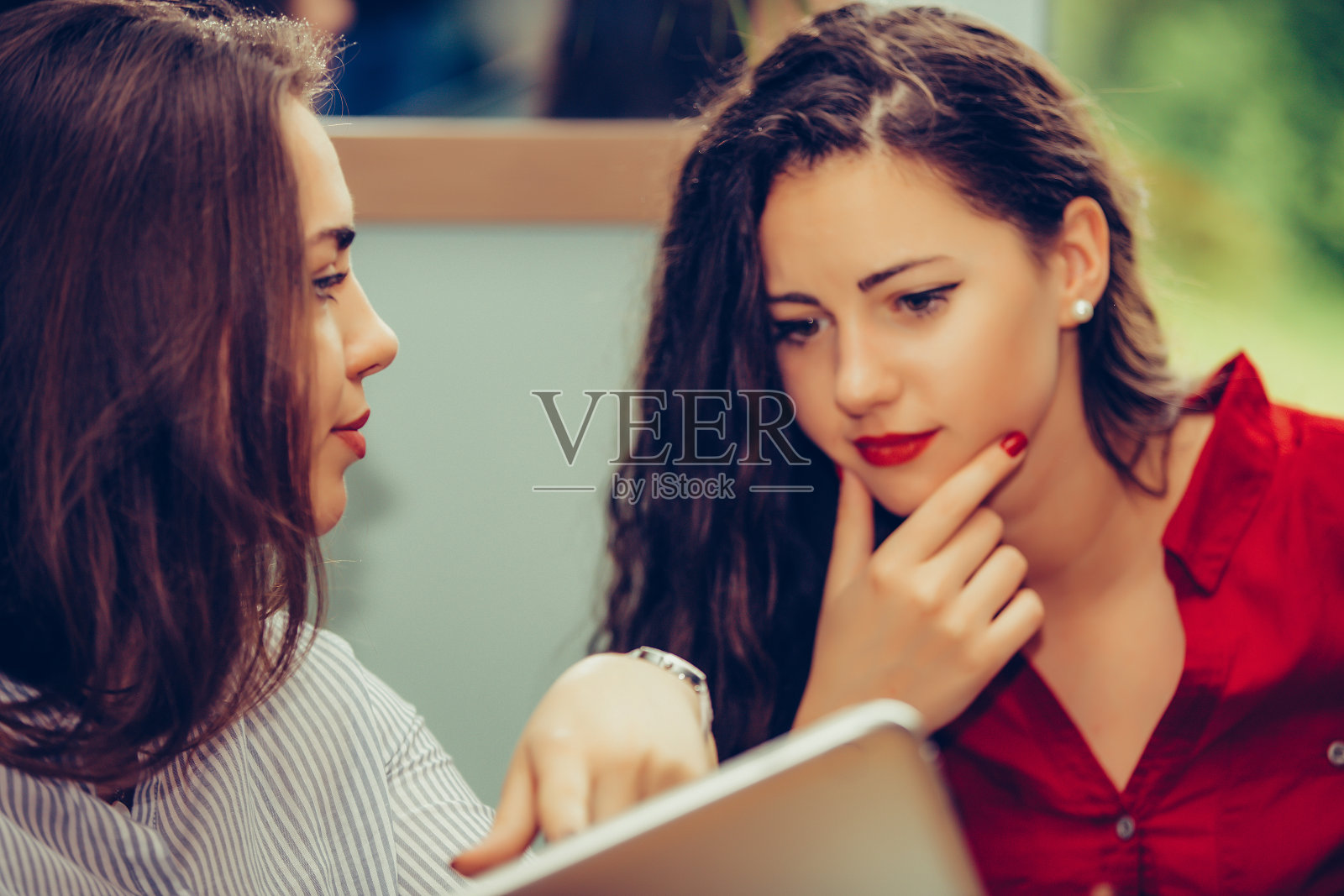 美女在平板电脑屏幕上向朋友展示信息照片摄影图片