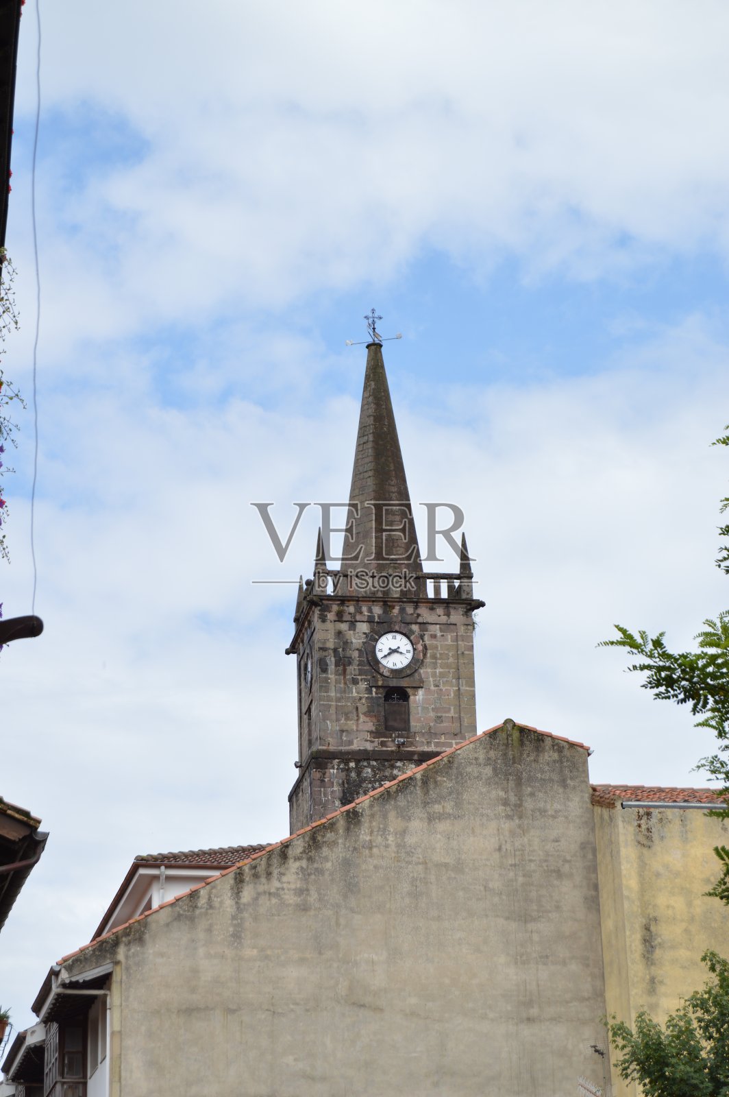 多云的日子里，位于别墅中心的圣克里斯托巴尔教堂钟楼。照片摄影图片