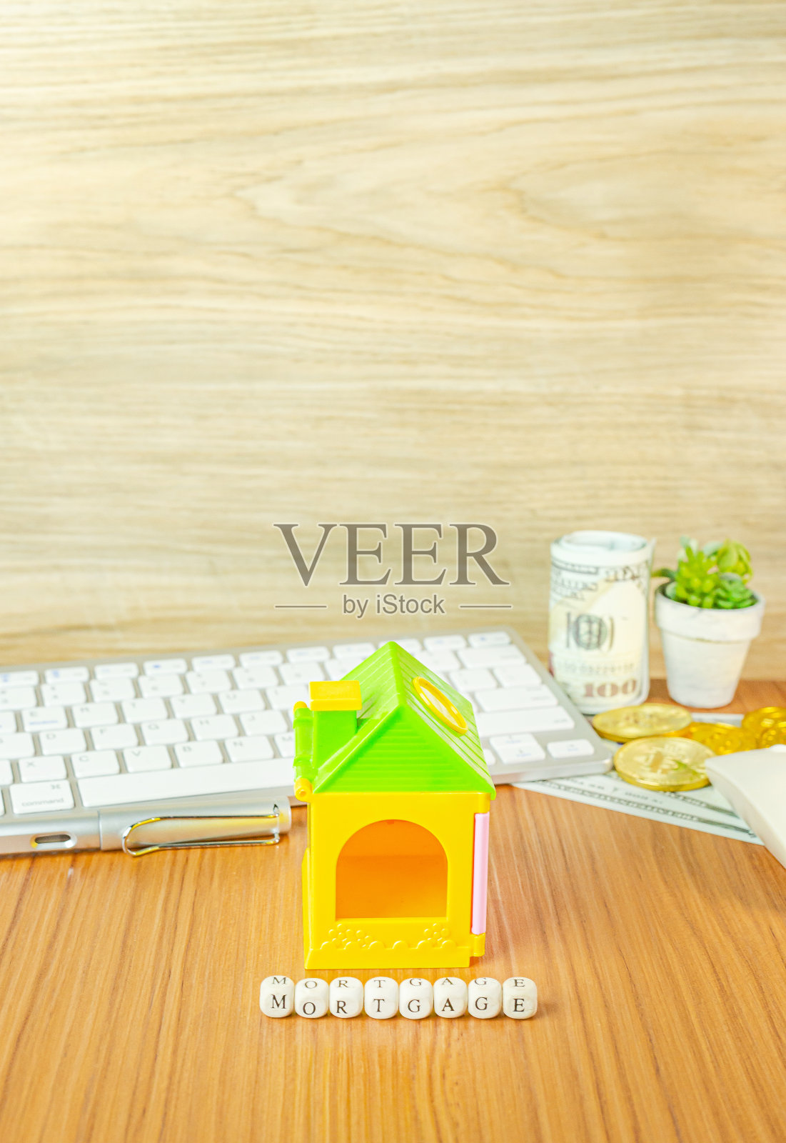 房屋玩具在办公室桌子上的抵押概念。照片摄影图片