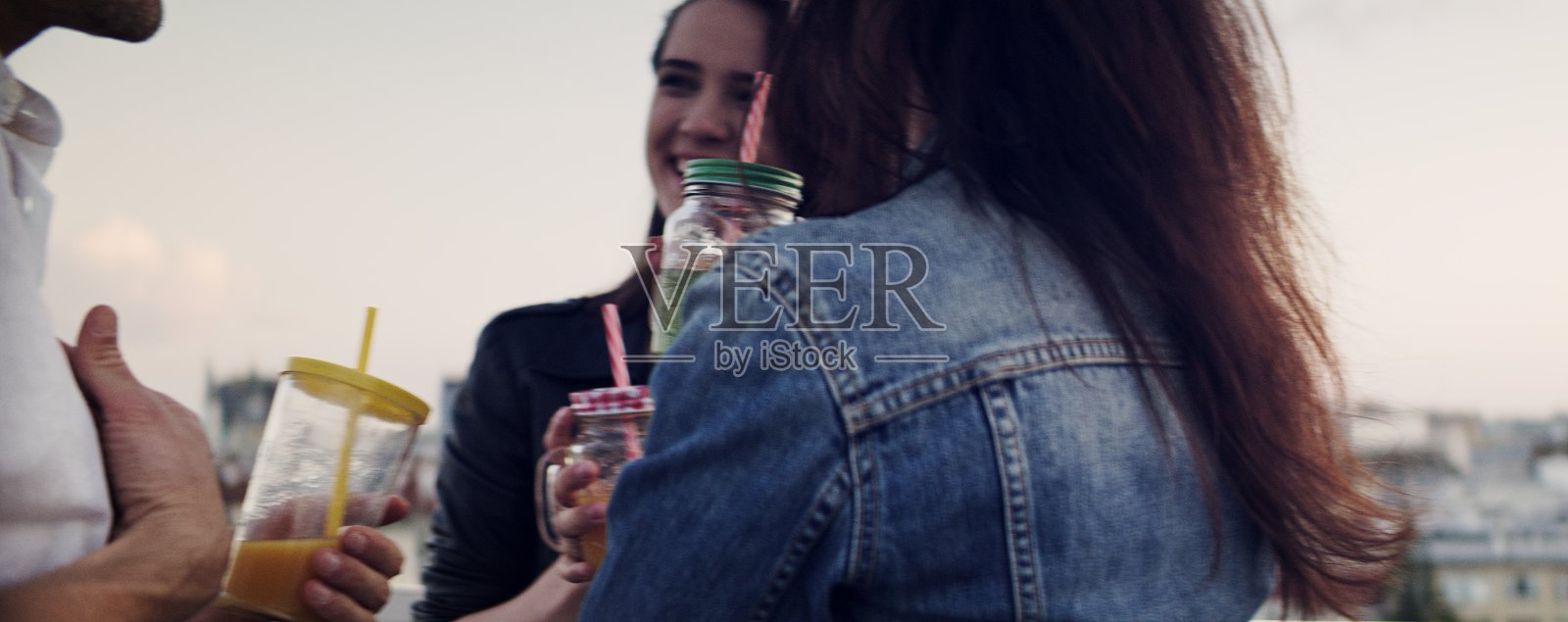 潮人朋友在屋顶聚会。庆祝的烤面包照片摄影图片