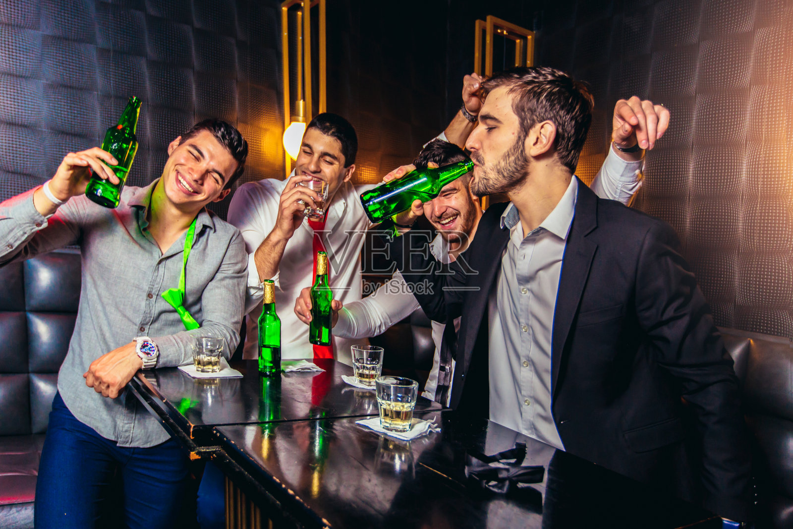 一群微笑的男性朋友在夜店里玩照片摄影图片
