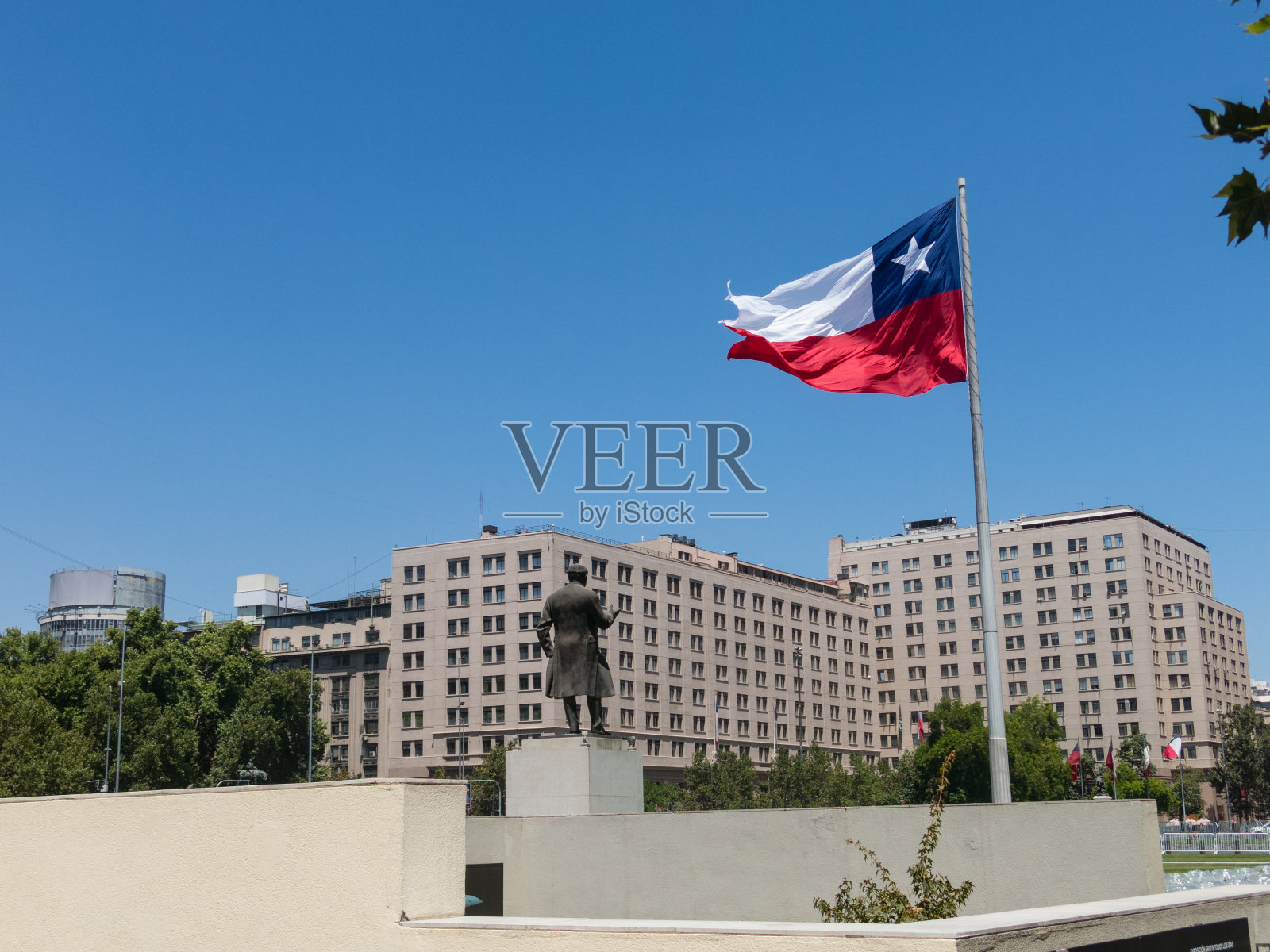 智利人民在智利圣地亚哥市中心的公民广场拉阿拉米达大道上的巨大国旗旁行走。智利。照片摄影图片