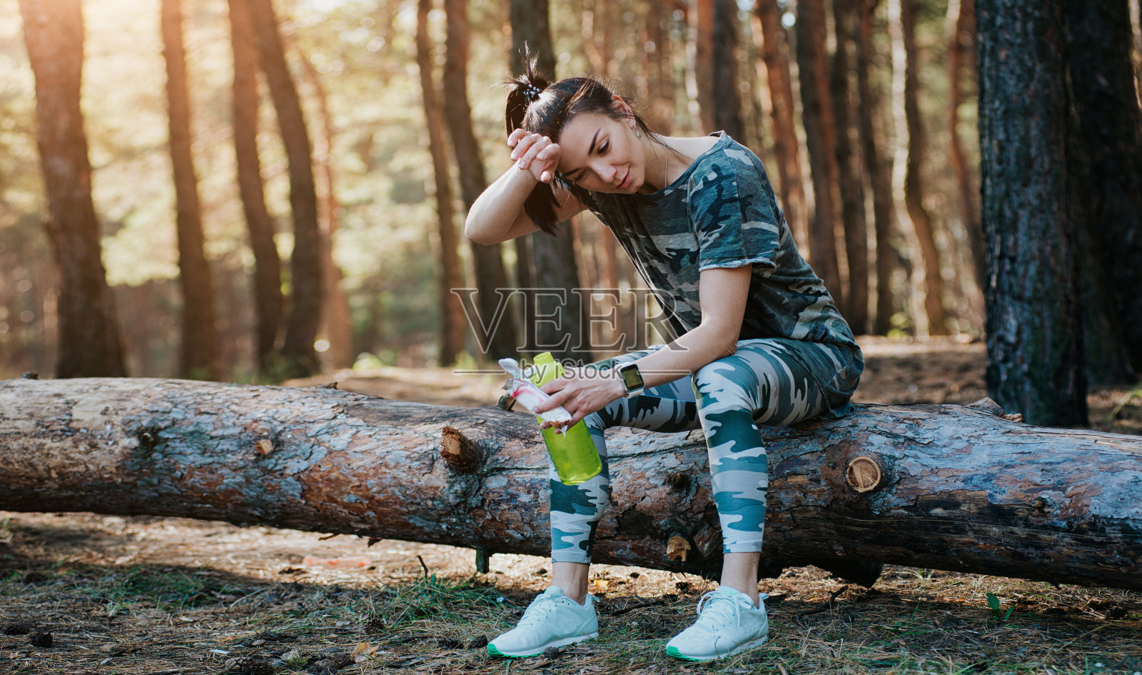 健康,运动的生活方式。年轻的女孩在运动服装休息后，锻炼，在公园慢跑，森林在秋天日落照片摄影图片