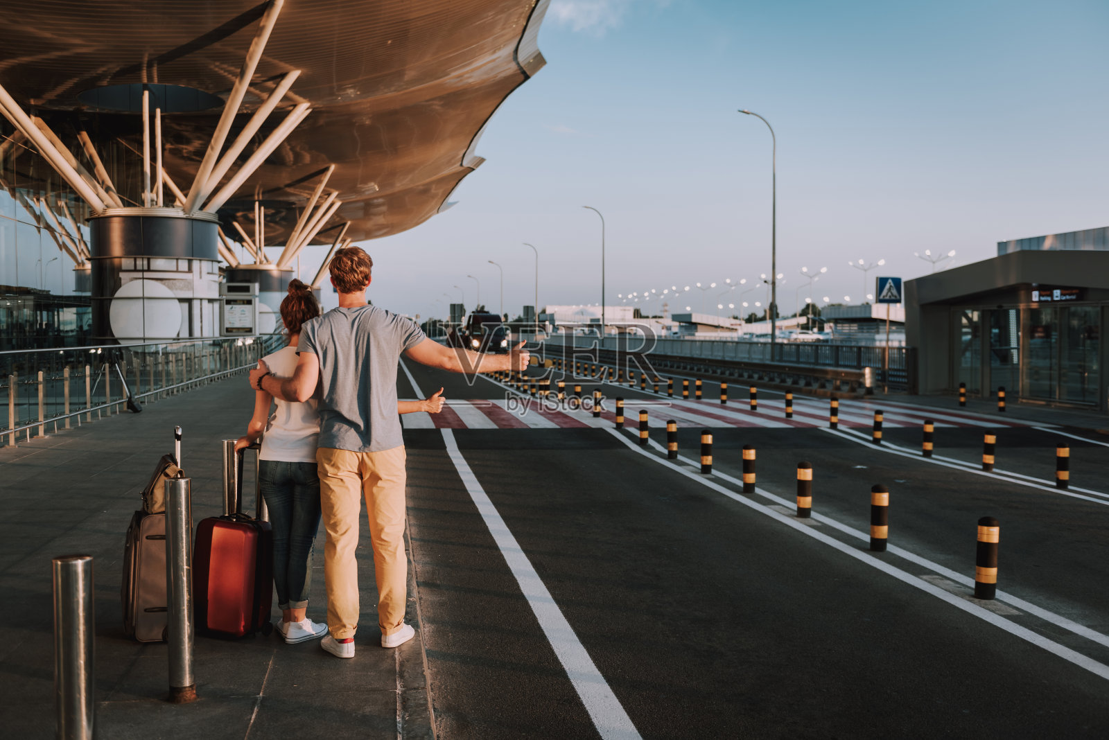 年轻夫妇拿着旅行袋试图拦出租车照片摄影图片