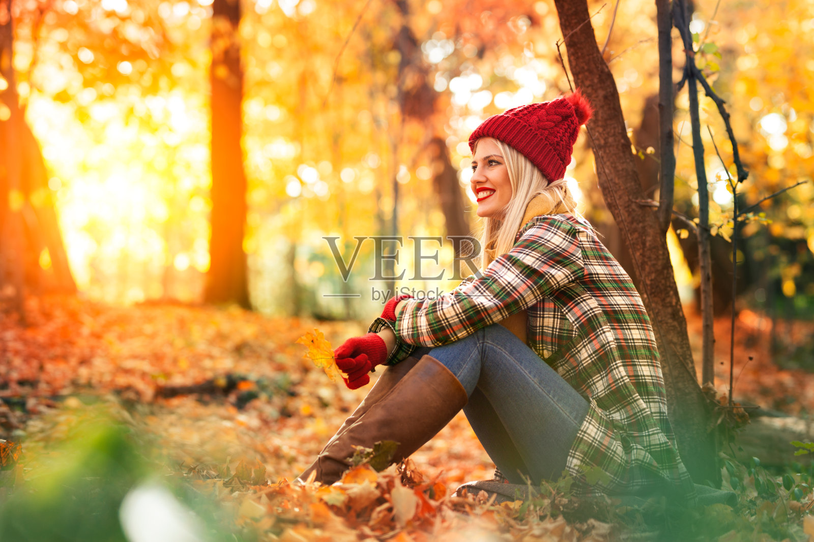 女人坐在秋天的公园，享受美丽的自然照片摄影图片