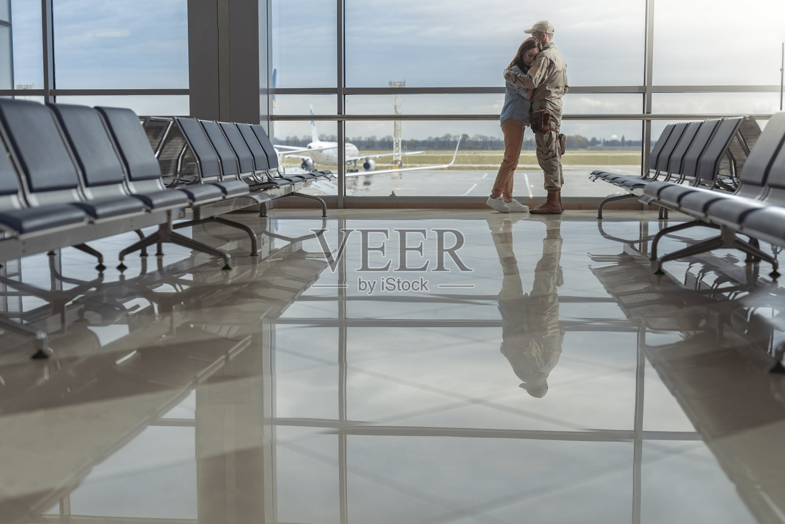 大窗边情侣相拥的侧视图照片摄影图片