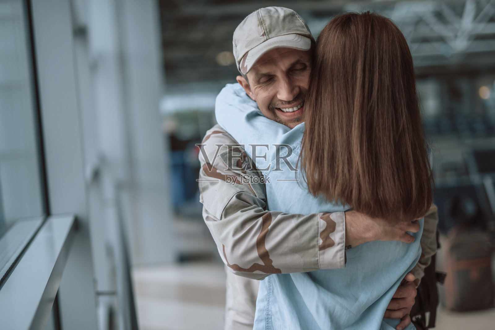 一对快乐的年轻情侣在大厅里拥抱照片摄影图片