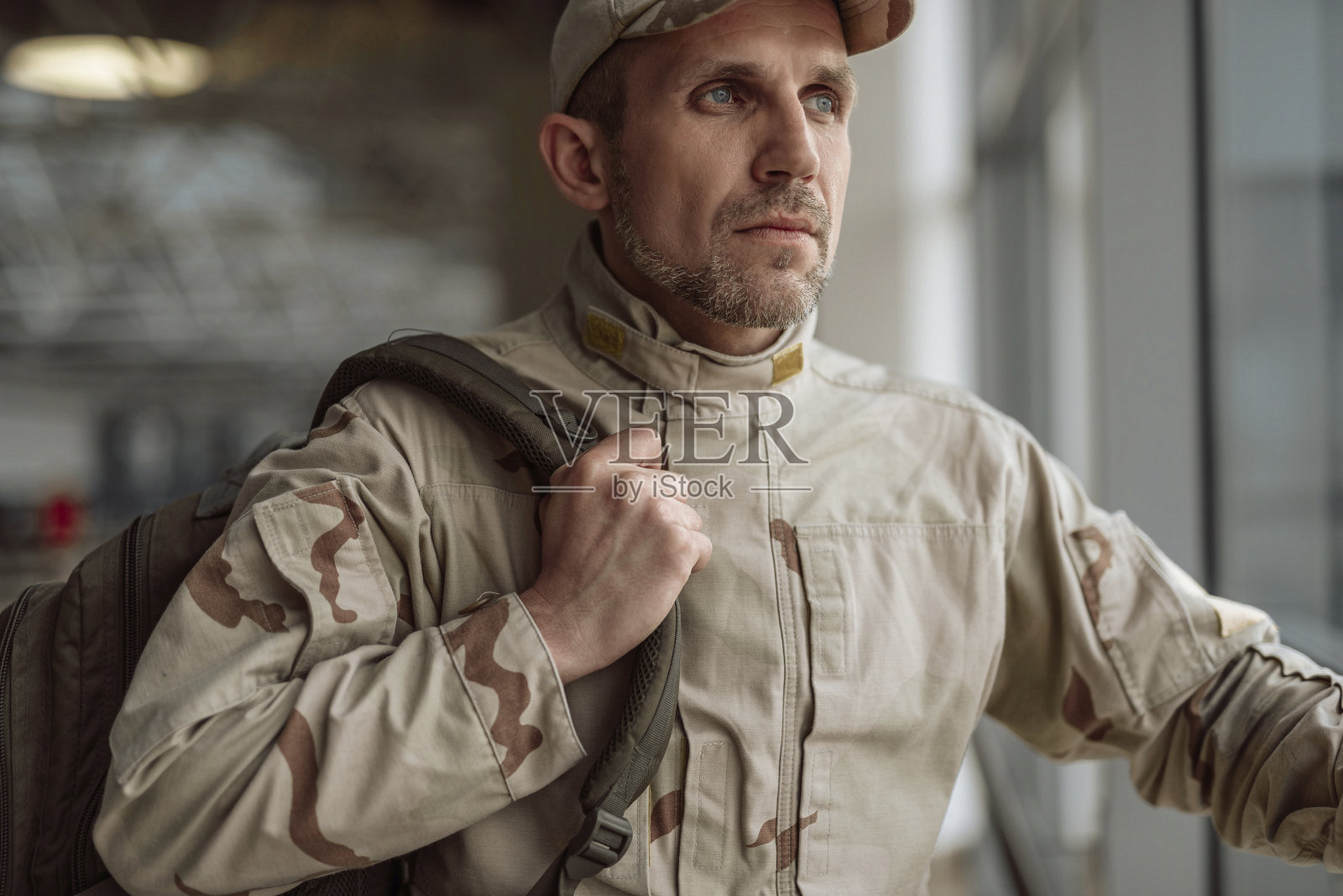 穿着迷彩服的严肃的美国士兵的腰上看向别处照片摄影图片