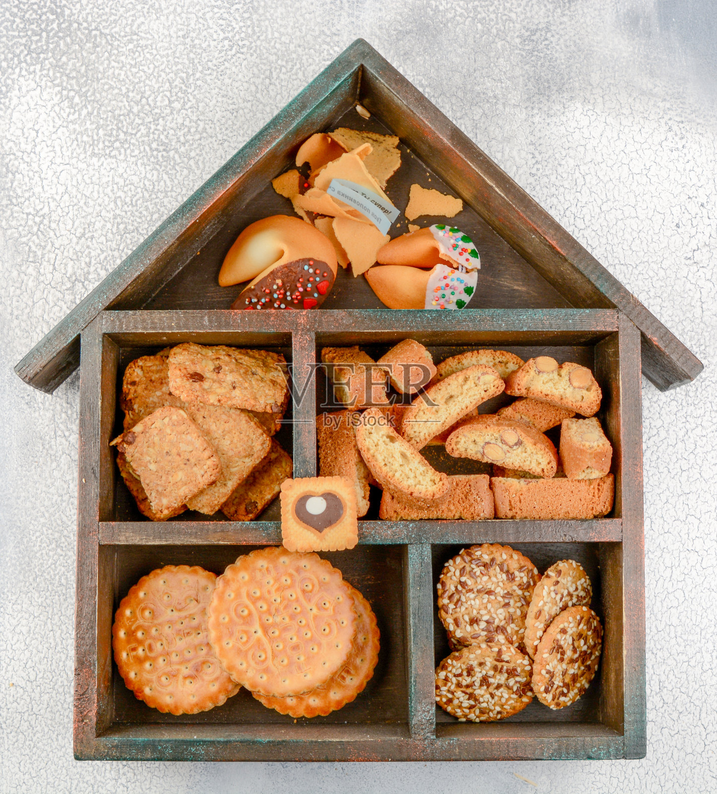 不同种类的饼干:麦片饼干、墨西哥薄饼、中式饼干和泡芙饼干，放在一个房子形状的木箱里。照片摄影图片