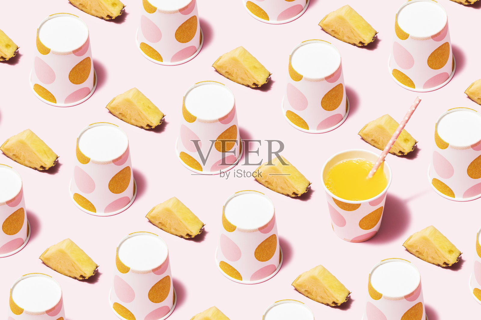 菠萝汁和圆点纸杯平铺在粉红色的背景上照片摄影图片