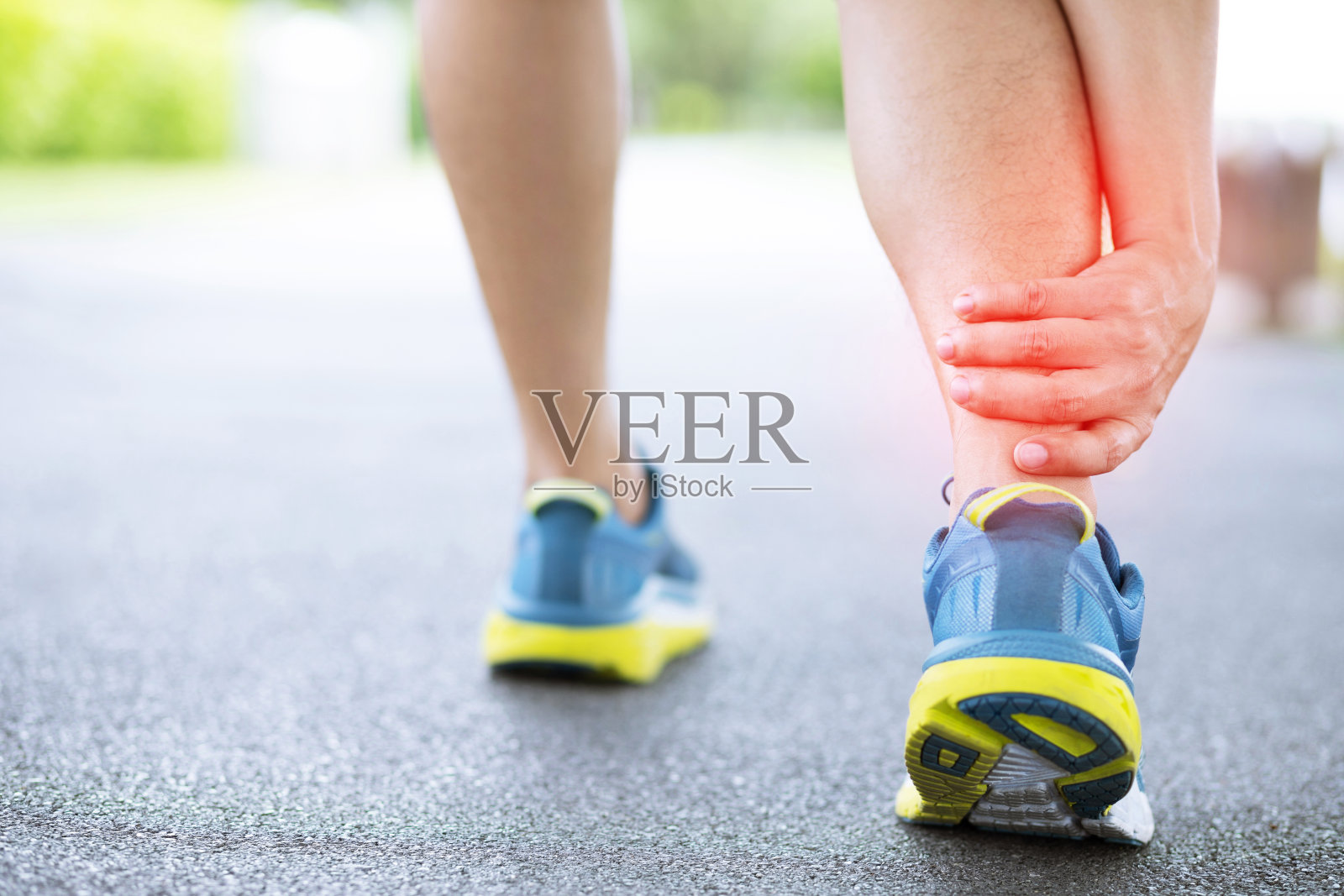 跑步者触碰疼痛扭曲或骨折的脚踝。运动员跑步训练事故。运动跑步时脚踝扭伤扭伤造成膝盖受伤。腿骨疼痛。把红色的腿集中在上面表示疼痛。照片摄影图片