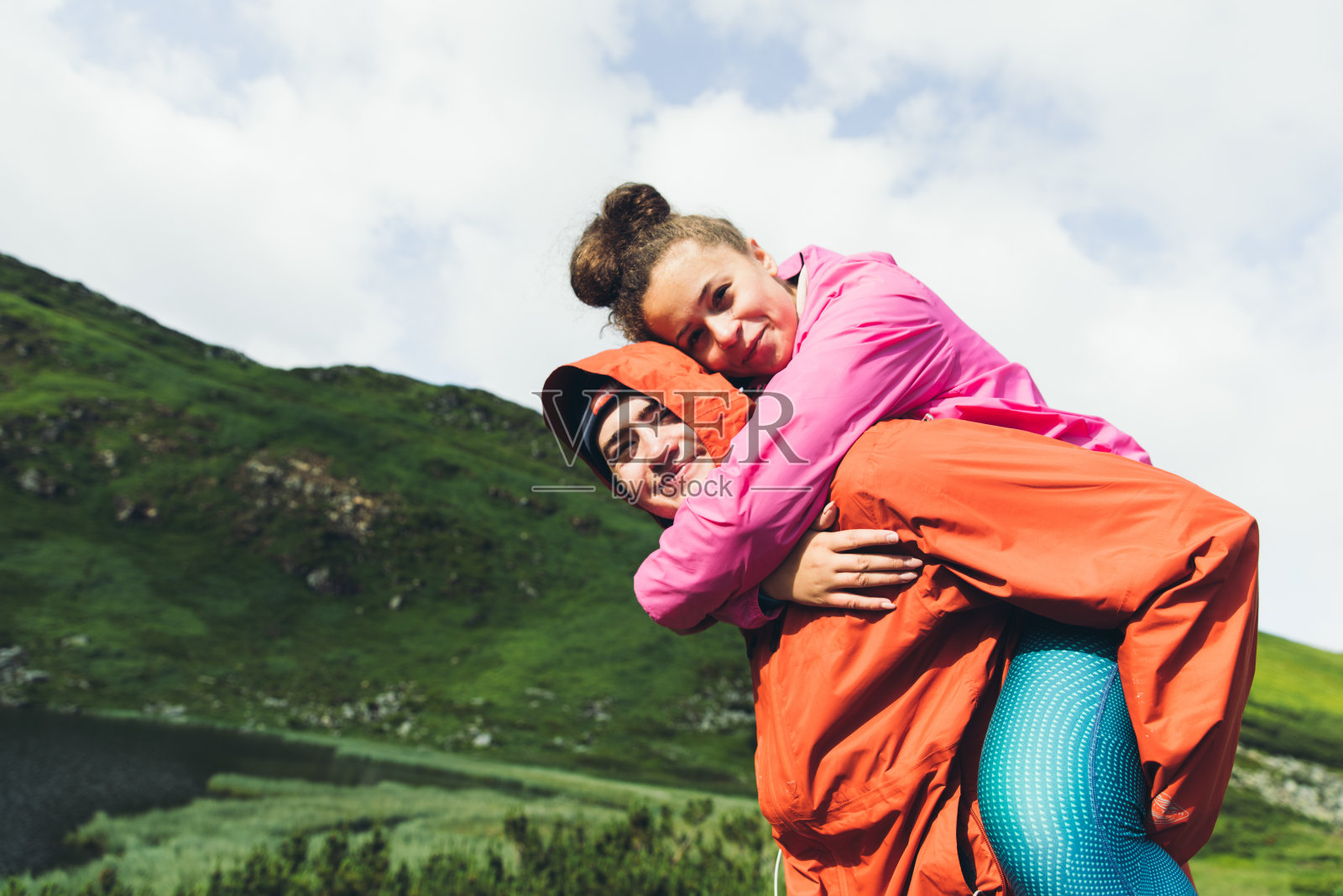 年轻夫妇在美丽的湖附近的山上玩耍照片摄影图片