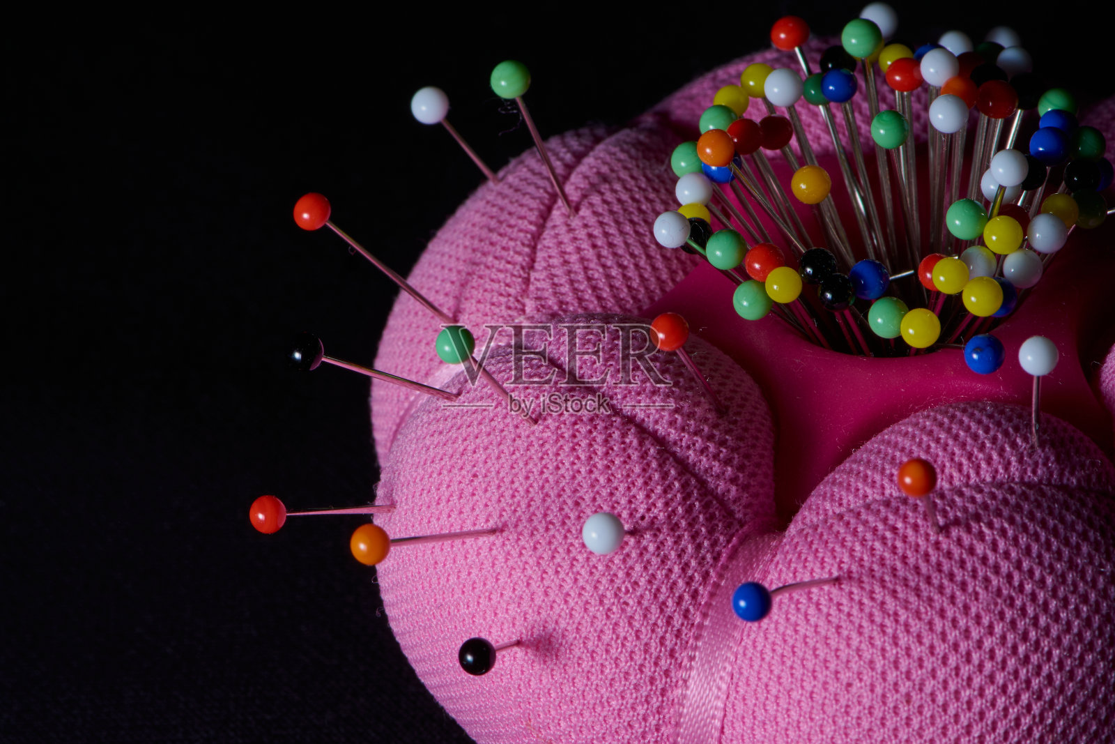 粉红色针垫与彩色大头针照片摄影图片