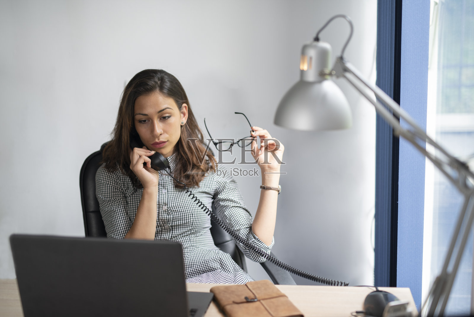 在办公室工作的女商人。照片摄影图片