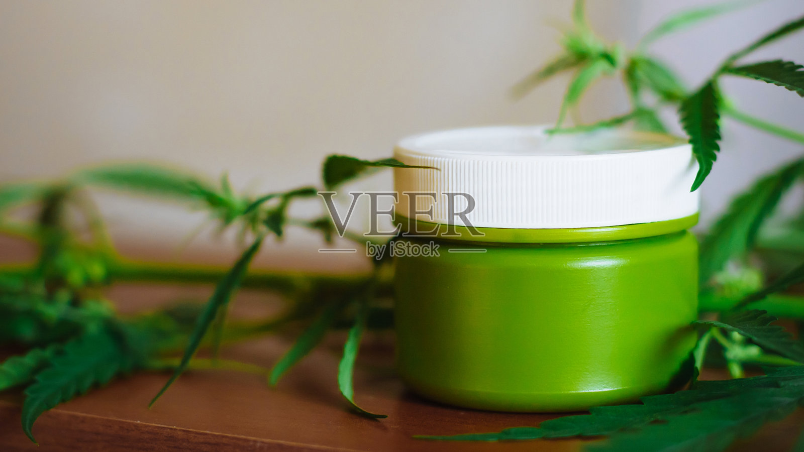 大麻大麻膏以大麻叶为背景——大麻概念自我保健中的大麻保健。桌子上有大麻提取物的化妆品。有机草药CBD产品照片摄影图片