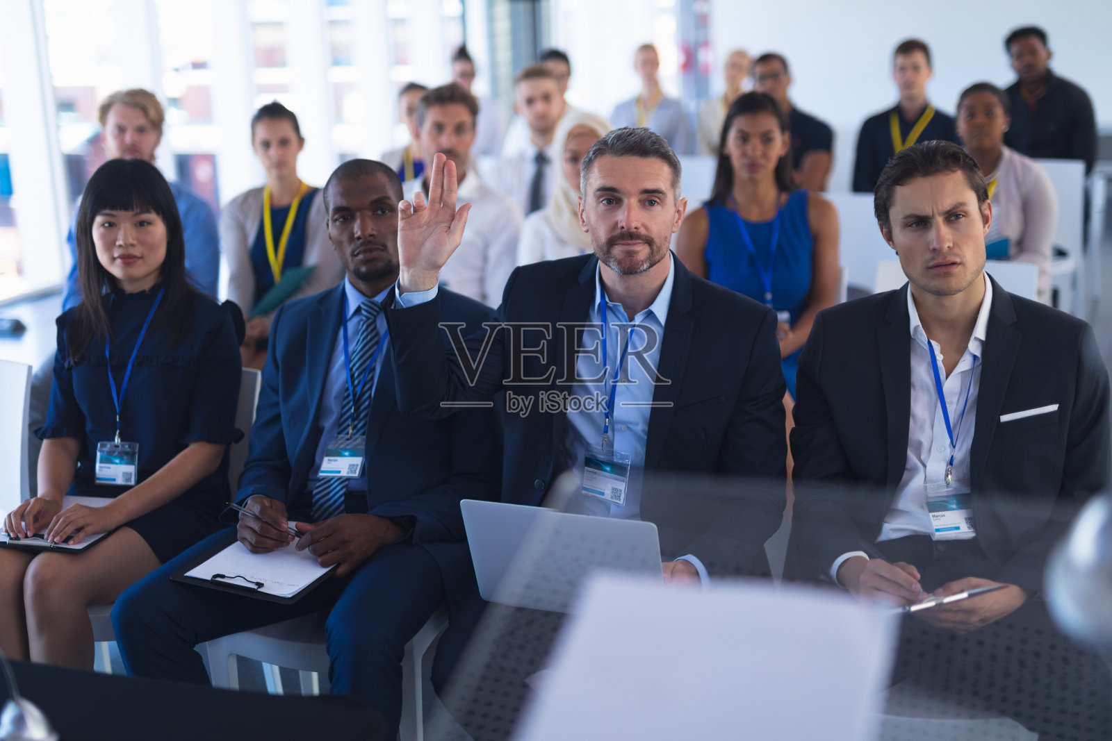 商人在参加商务研讨会时举手照片摄影图片