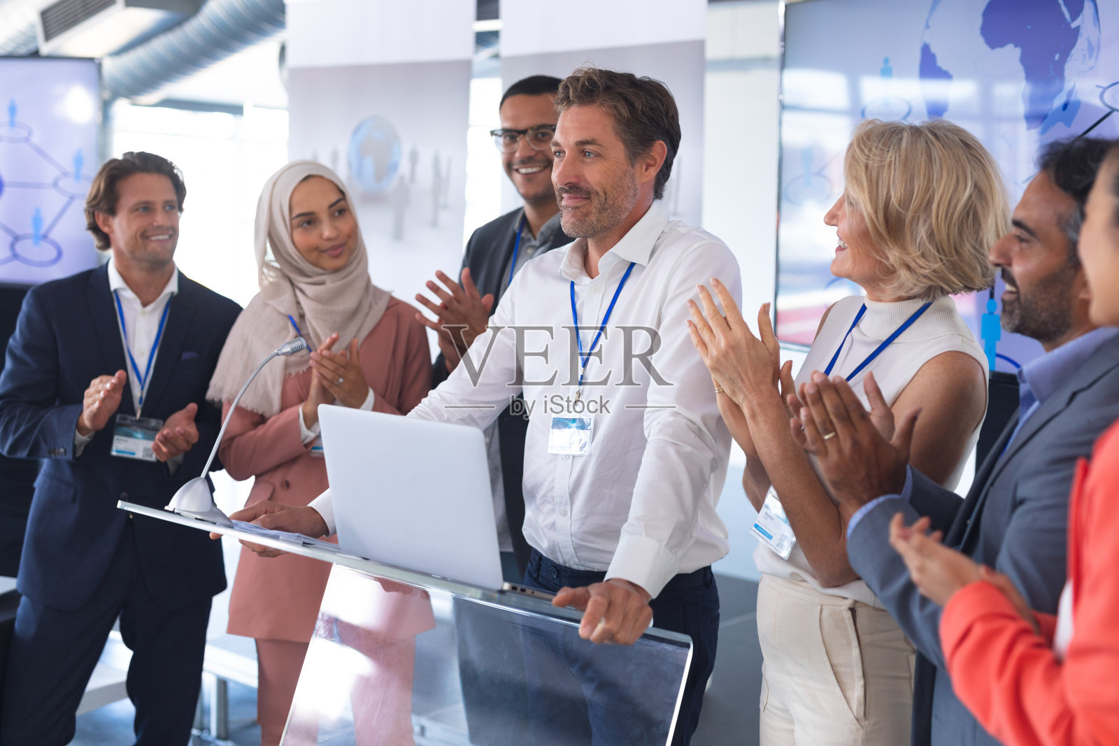 商人与同事站在一起，在商业研讨会上发言照片摄影图片