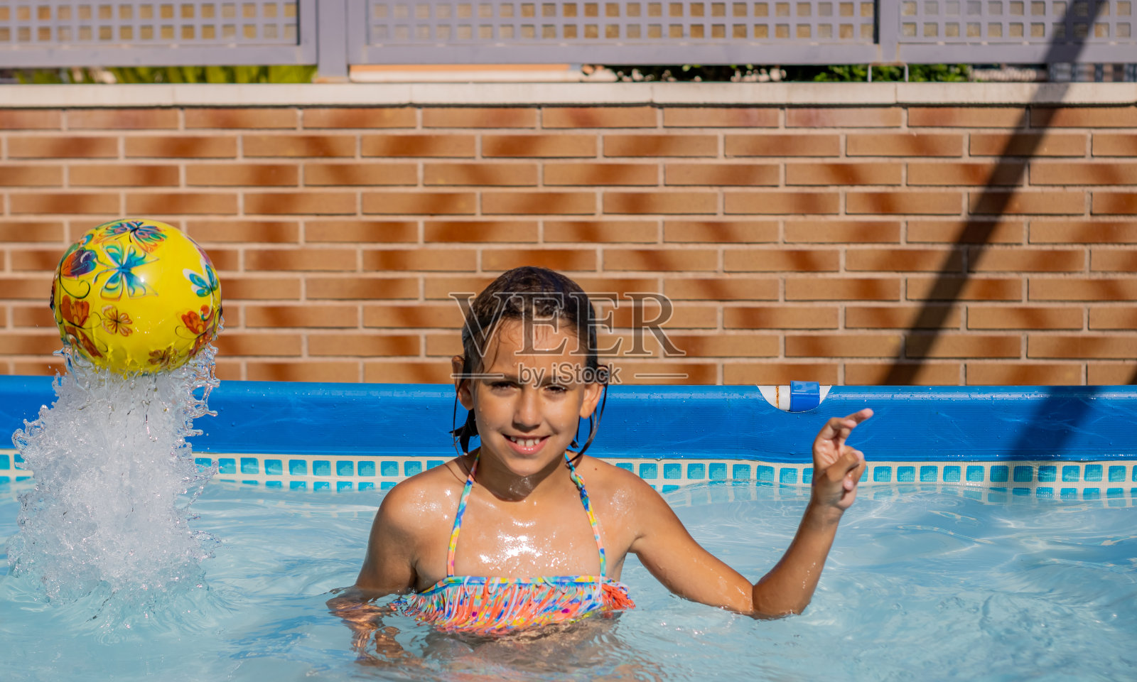 游泳池里有个小女孩照片摄影图片