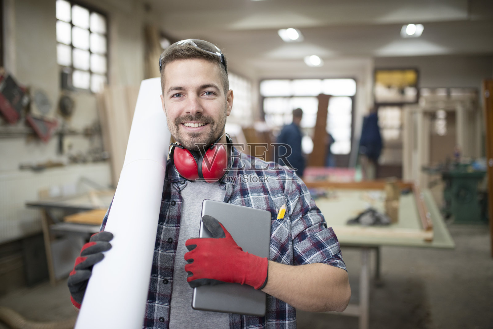 经验丰富的建筑师设计师在工作室手持平板和项目设计文件的肖像。照片摄影图片