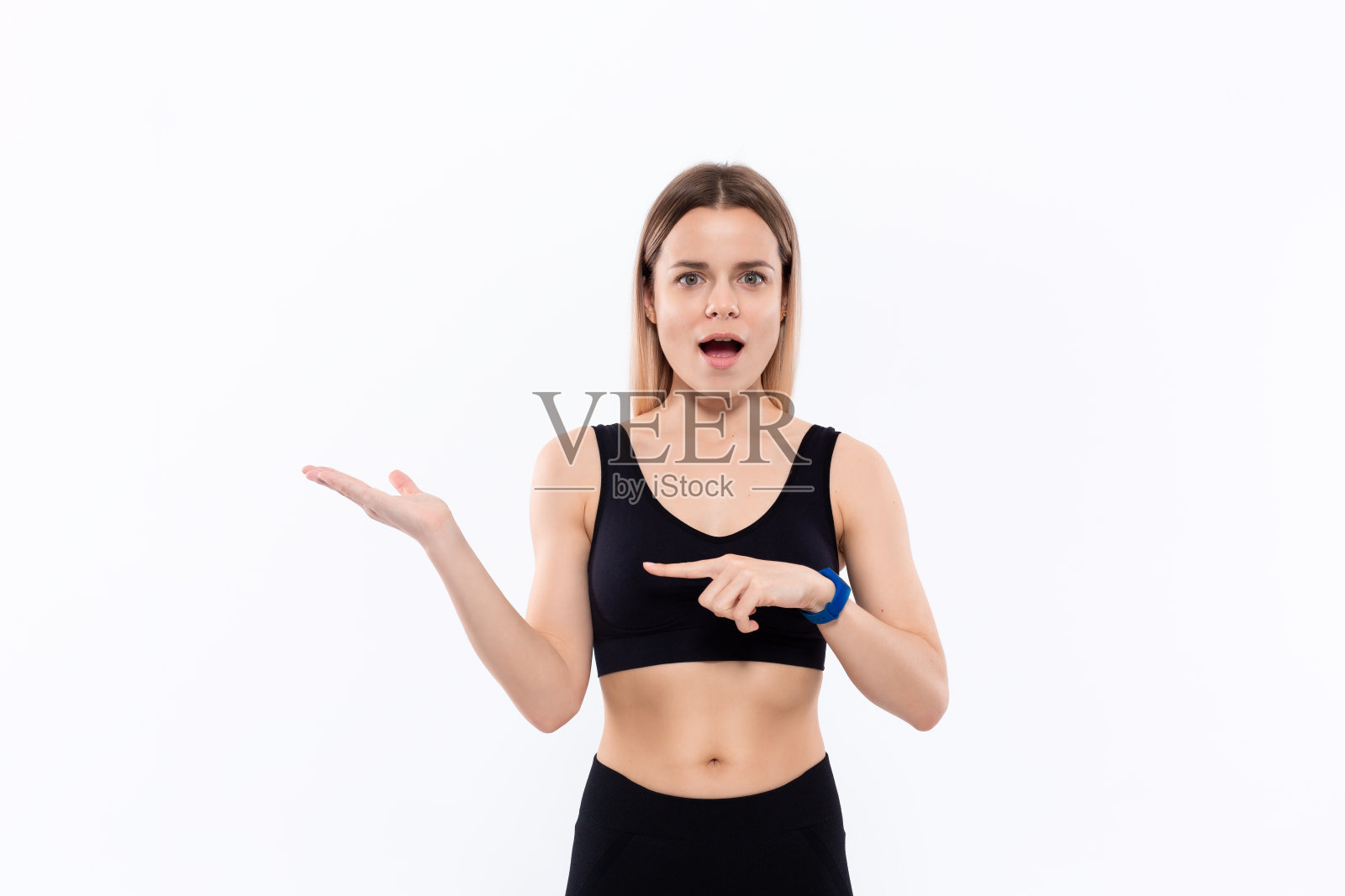 年轻的运动金发女人穿着黑色运动服与智能手表脉搏测量指向与一只手的脉搏照片摄影图片