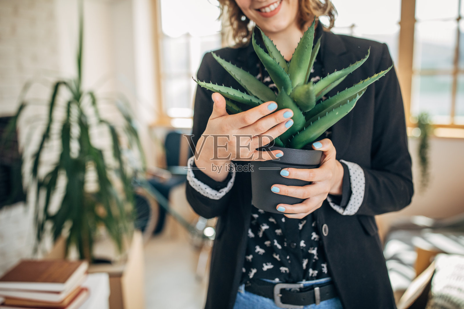 一位女士为她的新公寓举着仙人掌照片摄影图片