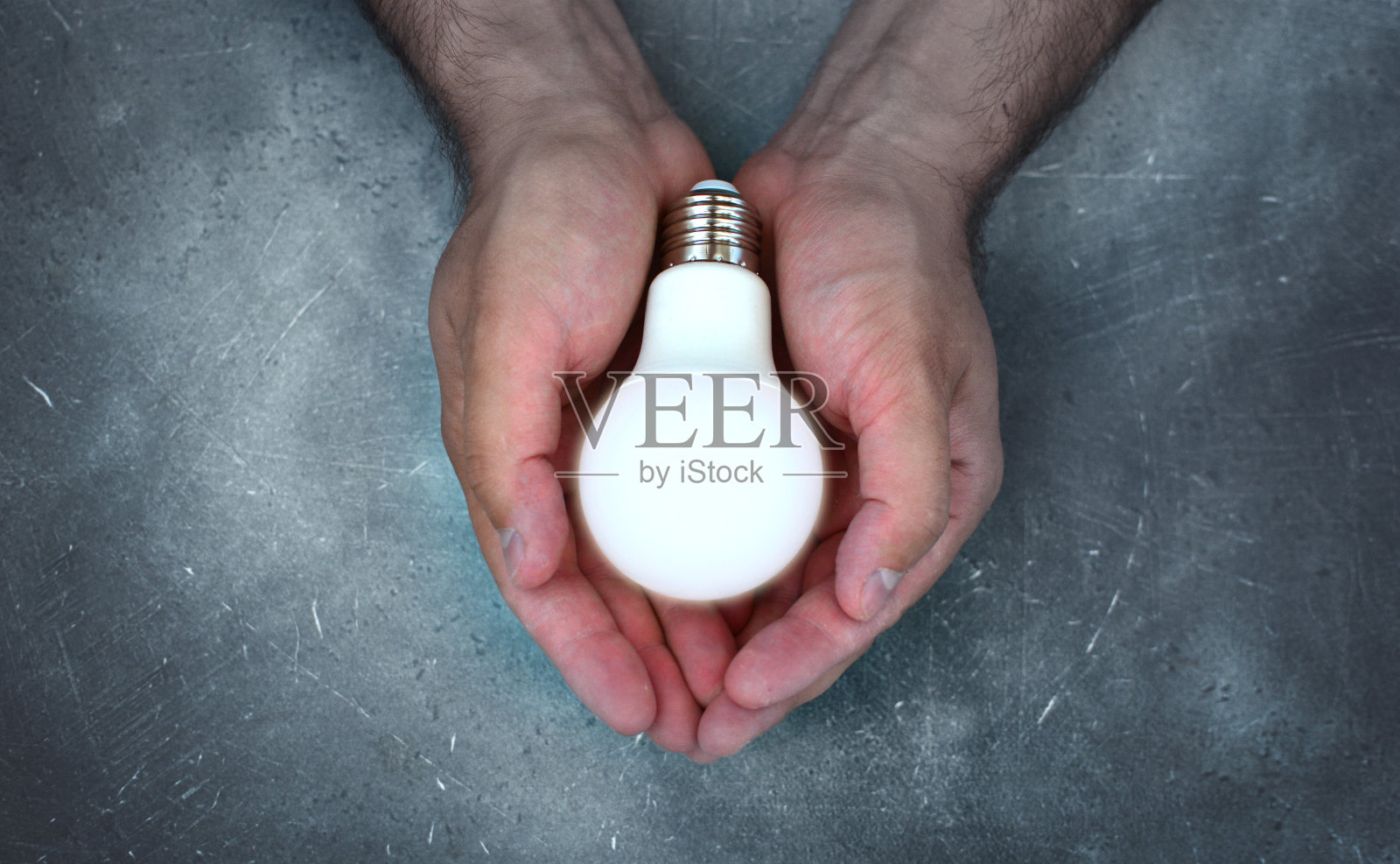希望的概念与灯泡在强有力的野蛮男性手中。照片摄影图片