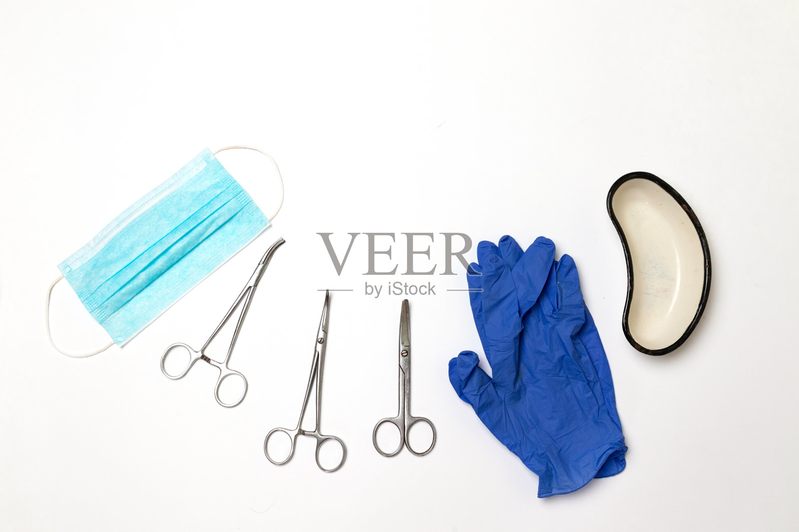 不锈钢医用级针夹，蓝色乳胶手套，灰色背景上的金属容器照片摄影图片