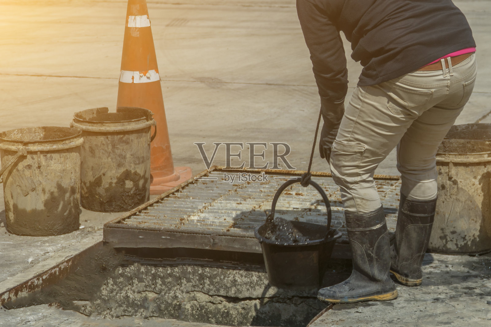 在街道上清理排水管或管道的污水处理工人照片摄影图片