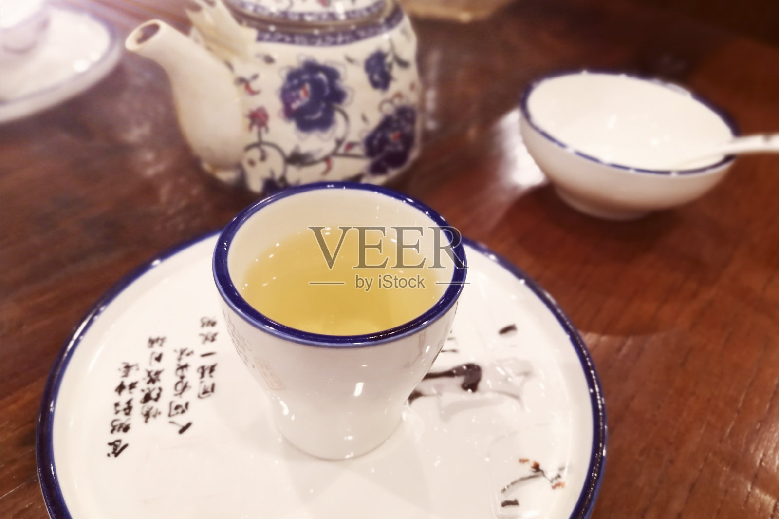 木桌上放着一杯茶和一个茶壶照片摄影图片