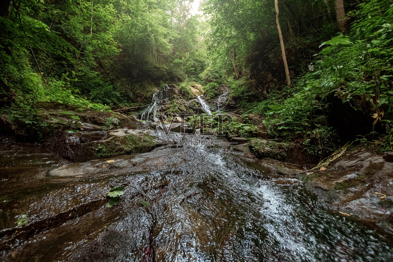 小绿森林瀑布在洞山中，瀑布在山间流淌。活动假期的概念，假期照片摄影图片