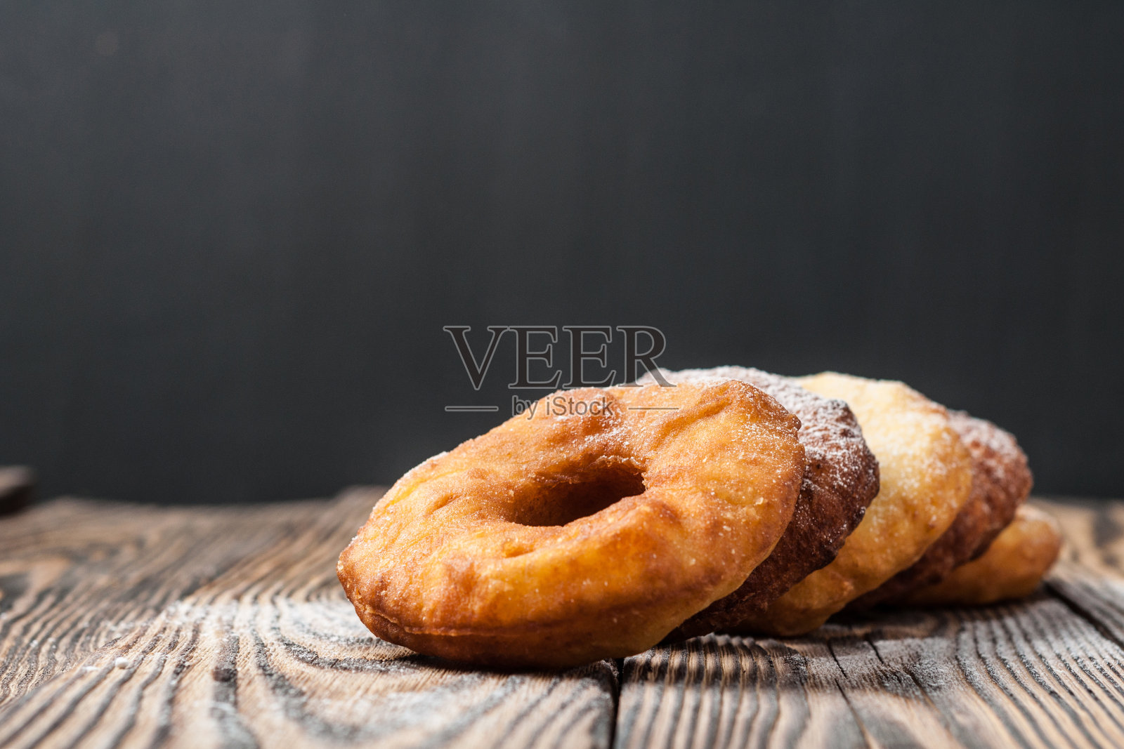 许多自制的不加奶油的烤甜甜圈，撒上了糖粉放在破旧的木桌上照片摄影图片