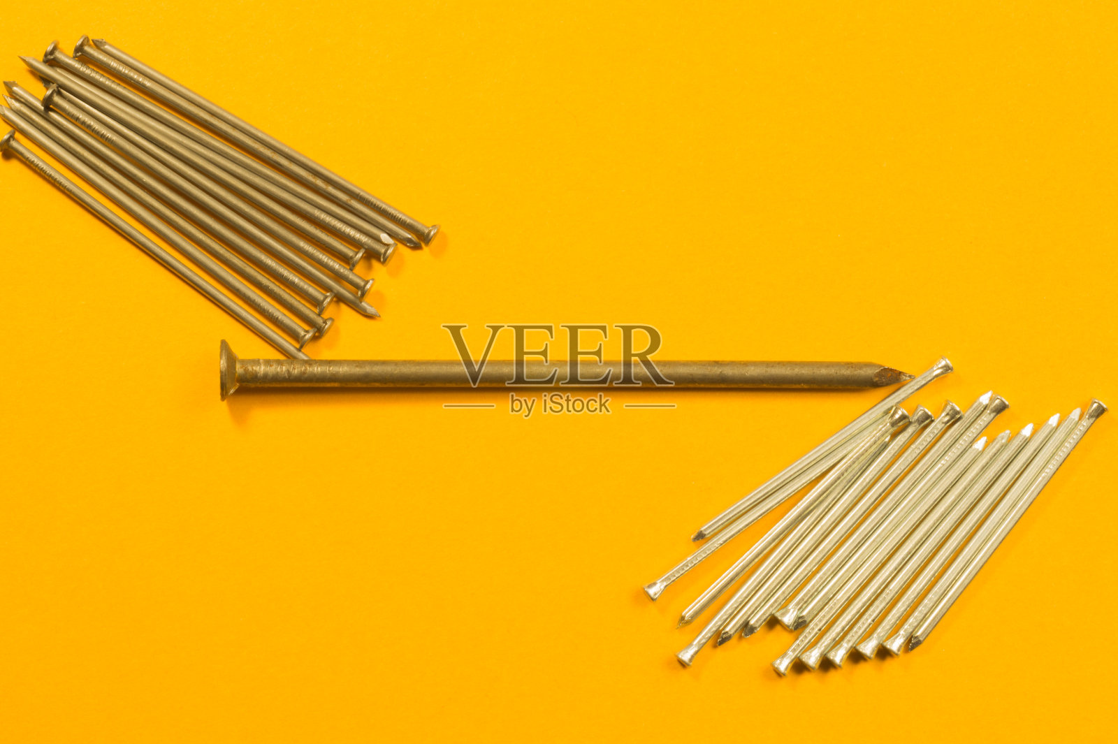 金属钉孤立在黄色背景上。工作的工具照片摄影图片